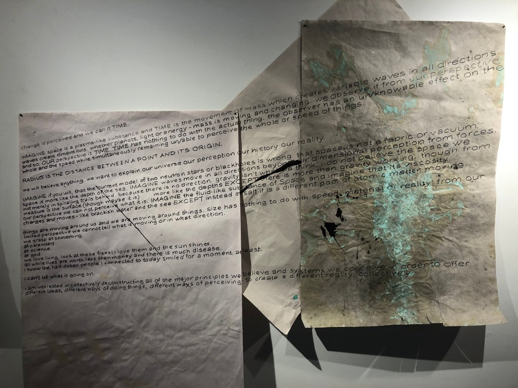 three sheets of grey paper staggered and layered w minimal marks of sharpie, black paint, and turqiouse patina from copper along with this piece of writing